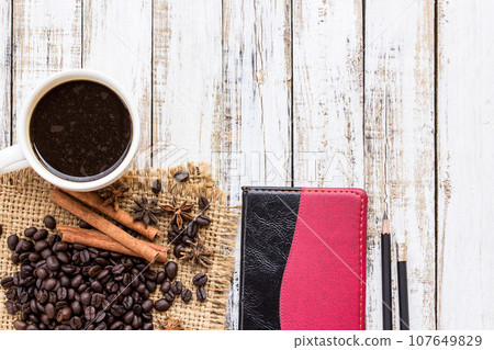 Coffee cup and notebook on white wooden table 107649829