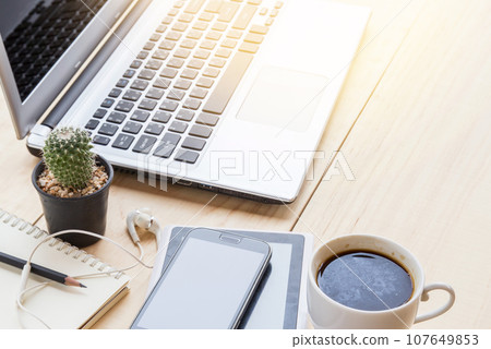 Office desk table with laptop computer, coffee cup and smart phone. Office desk table with laptop computer, coffee cup and smart phone. 107649853
