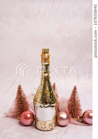 Happy New Year! toy bottle on light concrete background with Christmas decorations, space for text Happy New Year! toy bottle on light concrete background with Christmas decorations, space for text 107650640