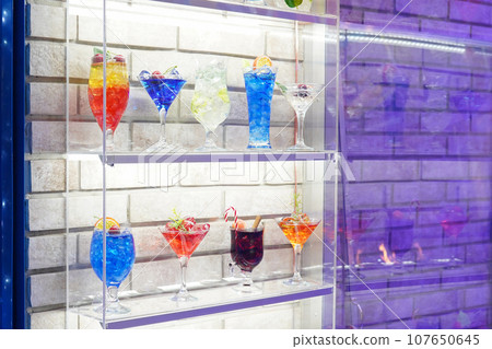 Variation alcoholic drinks served on bar counter. Colored drinks in glasses. Beautiful background, evening mood 107650645