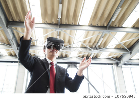 Young businessman using VR in warehouse Young businessman using VR in warehouse 107650945