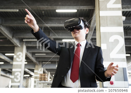 Young businessman using VR in warehouse Young businessman using VR in warehouse 107650946