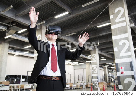 Young businessman using VR in warehouse Young businessman using VR in warehouse 107650949