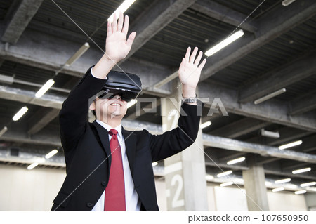 Young businessman using VR in warehouse Young businessman using VR in warehouse 107650950