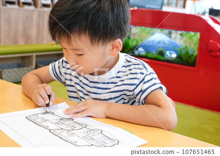 boy playing with coloring book boy playing with coloring book 107651465