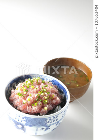 Seared tuna bowl topped with lots of green onions and piping hot miso soup 107653404