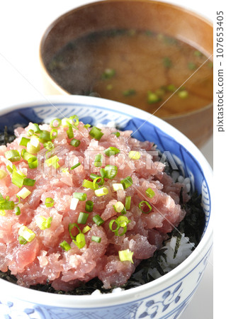Seared tuna bowl topped with lots of green onions and piping hot miso soup 107653405