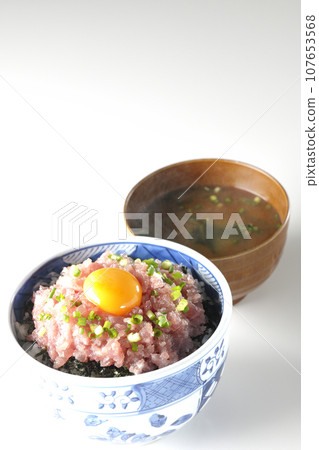 Seared tuna bowl topped with green onion and egg yolk and piping hot miso soup 107653568