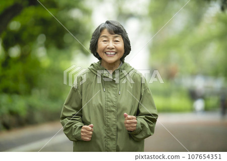 Senior woman jogging with a smile 107654351