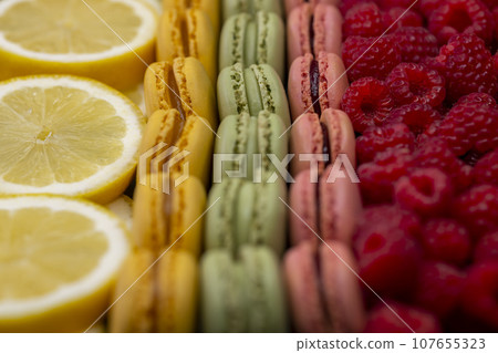 macaroons of different colors with raspberries and lemon macaroons of different colors with raspberries and lemon 107655323