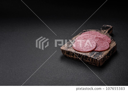 Delicious fresh smoked sausage with salt and spices cut into slices Delicious fresh smoked sausage with salt and spices cut into slices 107655383