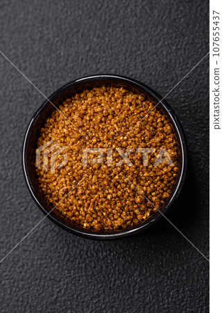 Crystals of brown Svan salt with spices in a black bowl Crystals of brown Svan salt with spices in a black bowl 107655437