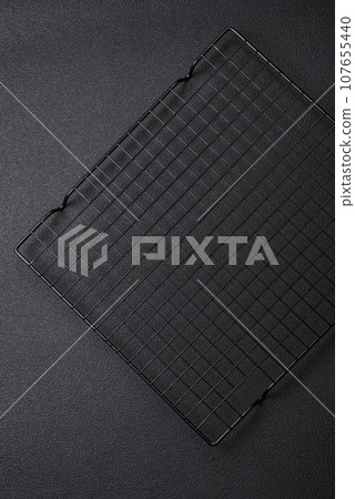 Empty black metal kitchen grate for pouring desserts Empty black metal kitchen grate for pouring desserts 107655440