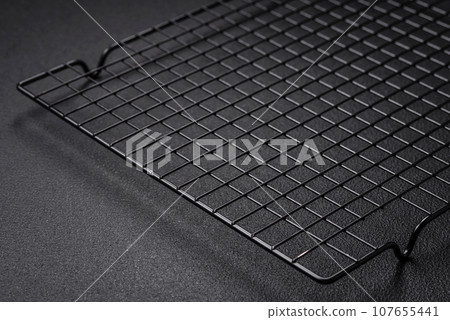 Empty black metal kitchen grate for pouring desserts Empty black metal kitchen grate for pouring desserts 107655441