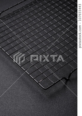 Empty black metal kitchen grate for pouring desserts 107655443