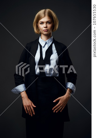 blonde businesswoman looking at camera on black background 107655530