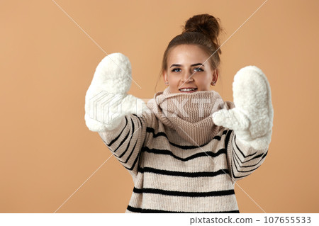 happy young woman in wool sweater and mittens happy young woman in wool sweater and mittens 107655533