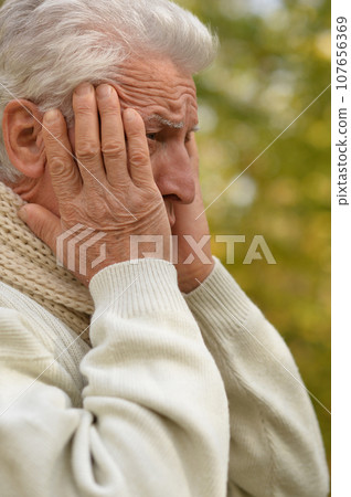 Portrait of an old man having a headache Portrait of an old man having a headache 107656369