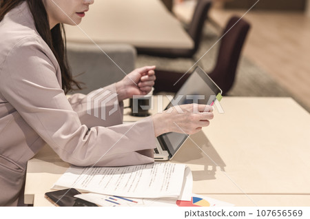 A woman pasting sticky notes on her laptop A woman pasting sticky notes on her laptop 107656569