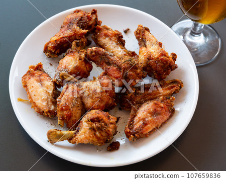 Fried chicken wings with golden crust served with on plate Fried chicken wings with golden crust served with on plate 107659836