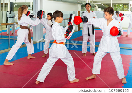Children practicing boxing punches in pairs 107660165