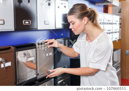 Young female choosing reliable mailbox in specialty shop 107660551