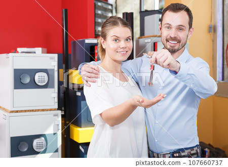 Young woman with boyfriend showing keys to their apartment in store Young woman with boyfriend showing keys to their apartment in store 107660737