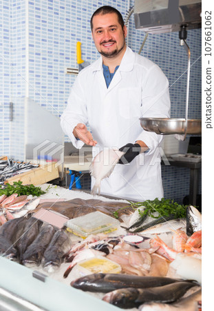 Seller holding fish 107661062