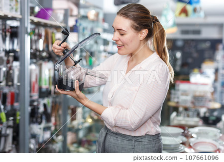 Adult woman is buying herb spinner for her kitchen in tableware store 107661096