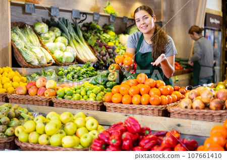 Young woman selling tangerines in shop 107661410