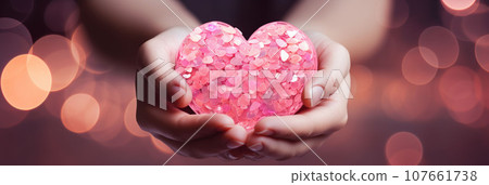 Glowing heart in female hands 107661738