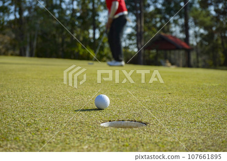 Golfers are putting golf in the evening golf course golf backglound. Golfers are putting golf in the evening golf course golf backglound. 107661895