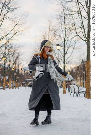 young European woman in winter clothes is skating 107665310
