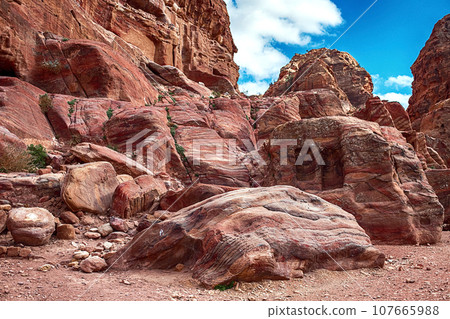 View of the Temples and caves carved into the sandstone rock in the gorge. Petra, Jordan View of the Temples and caves carved into the sandstone rock in the gorge. Petra, Jordan 107665988