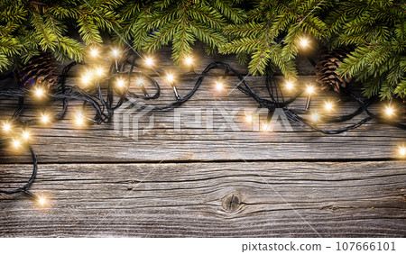 Christmas glowing garland and fir tree branches 107666101
