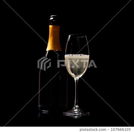 Champagne glass and bottle on a black 107666105