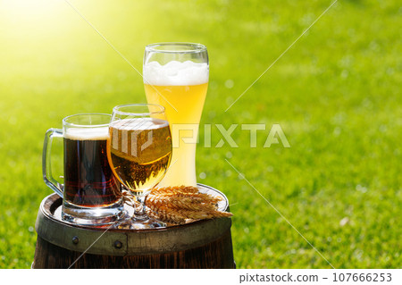 Variety of beer glasses on rustic wooden barrel 107666253