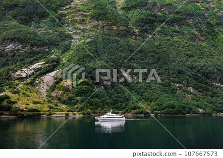 Motor yacht against a background of a tropical green landscape. 107667573