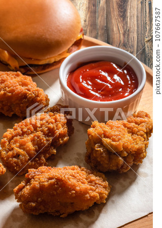 Chicken fried breaded with ketchup on a wooden tray Chicken fried breaded with ketchup on a wooden tray 107667587