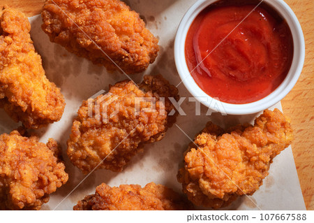 Delicious chicken wings in crispy breading with ketchup. Delicious chicken wings in crispy breading with ketchup. 107667588