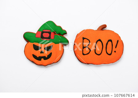 The hand-made eatable gingerbread Halloween pumpkins with boo inscription on white background The hand-made eatable gingerbread Halloween pumpkins with boo inscription on white background 107667614