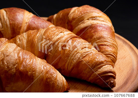 Fresh croissants on a cutting board close-up. French cuisine concept 107667688