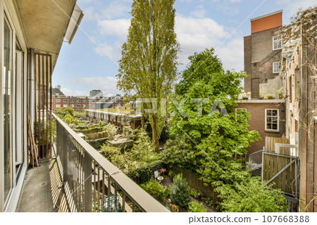 a balcony with trees and buildings in the background, taken from an apartment window looking out to the street below a balcony with trees and buildings in the background, taken from an apartment window looking out to the street below 107668388