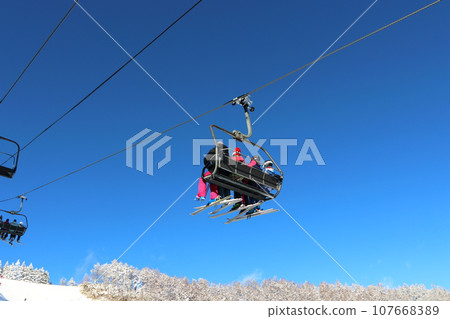 Ski resort - high-speed 4-person lift against the blue sky Ski resort - high-speed 4-person lift against the blue sky 107668389