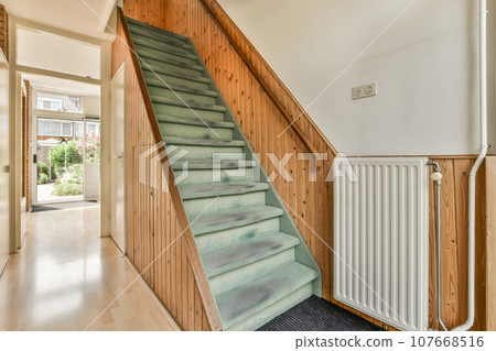 a staircase leading up to the second floor in a home with wood paneled walls and white trim on the stairs 107668516