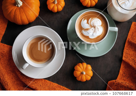 halloween decoration with latte and pumpkins on a wooden table, still life, cozy, holiday background with lights halloween decoration with latte and pumpkins on a wooden table, still life, cozy, holiday background with lights 107668617