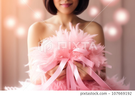 Pink ribbon in female hands close-up Pink ribbon in female hands close-up 107669192