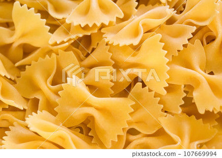 Texture of dry italian pasta pasta farfalle. Italian cuisine products. Products from durum flour 107669994