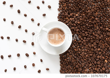 A cup of aromatic coffee and coffee grains on a white background, top view A cup of aromatic coffee and coffee grains on a white background, top view 107670175