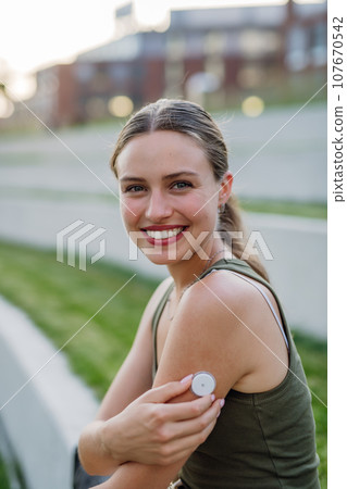Diabetic woman with continuous glucose monitor on arm. Diabetic woman with continuous glucose monitor on arm. 107670542